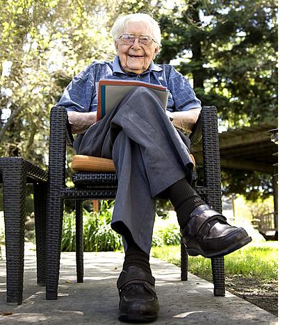 Glen sitting on a patio chair with a book in his lap