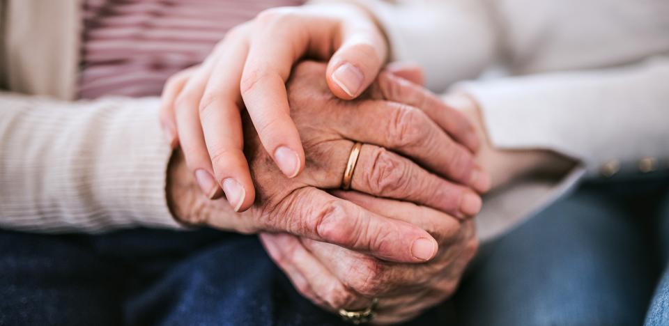 Two holding hands, one older and one younger.