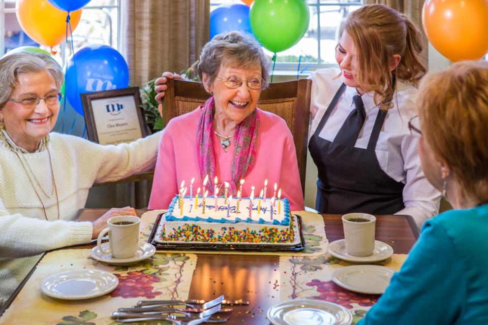 woman celebrating her 100th birthday with friends