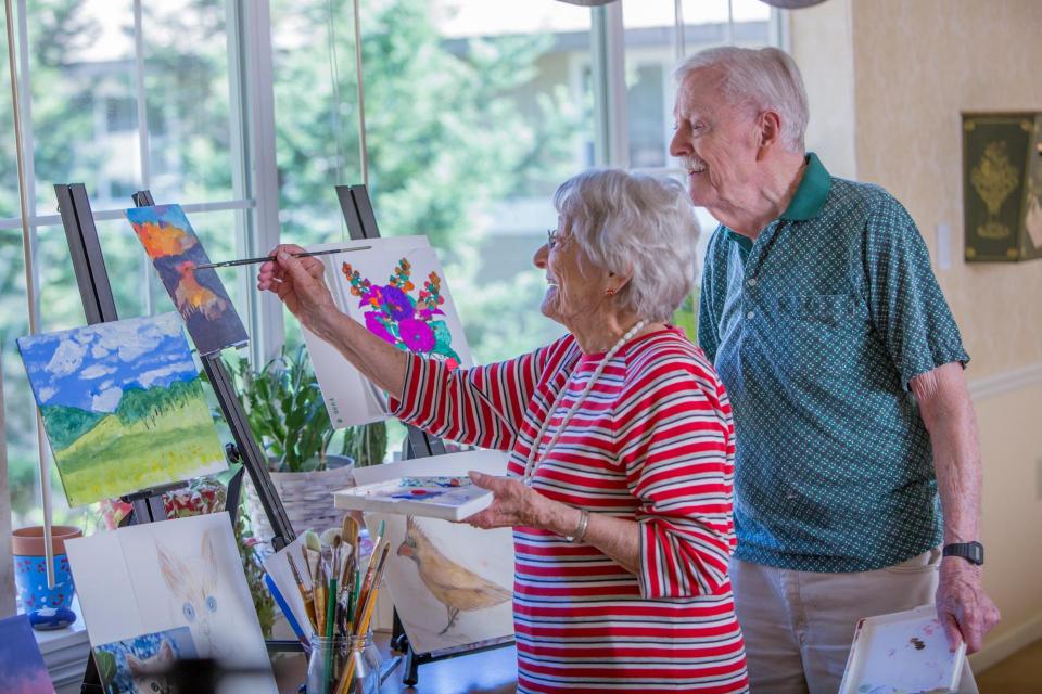 Resident couple painting a picture.