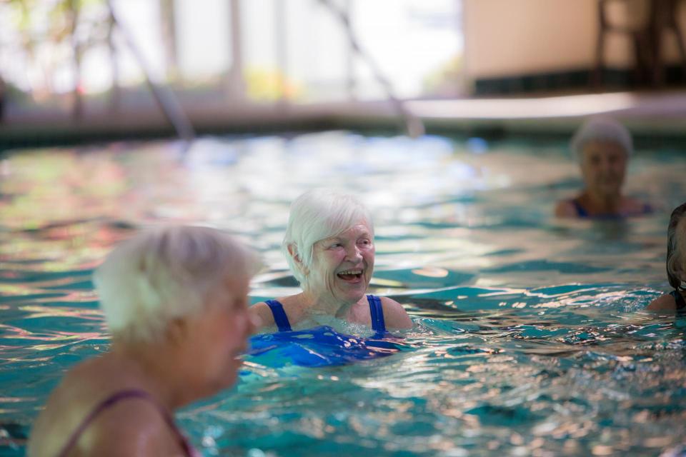 Residents enjoying a water aerobics class in the community indoor pool.