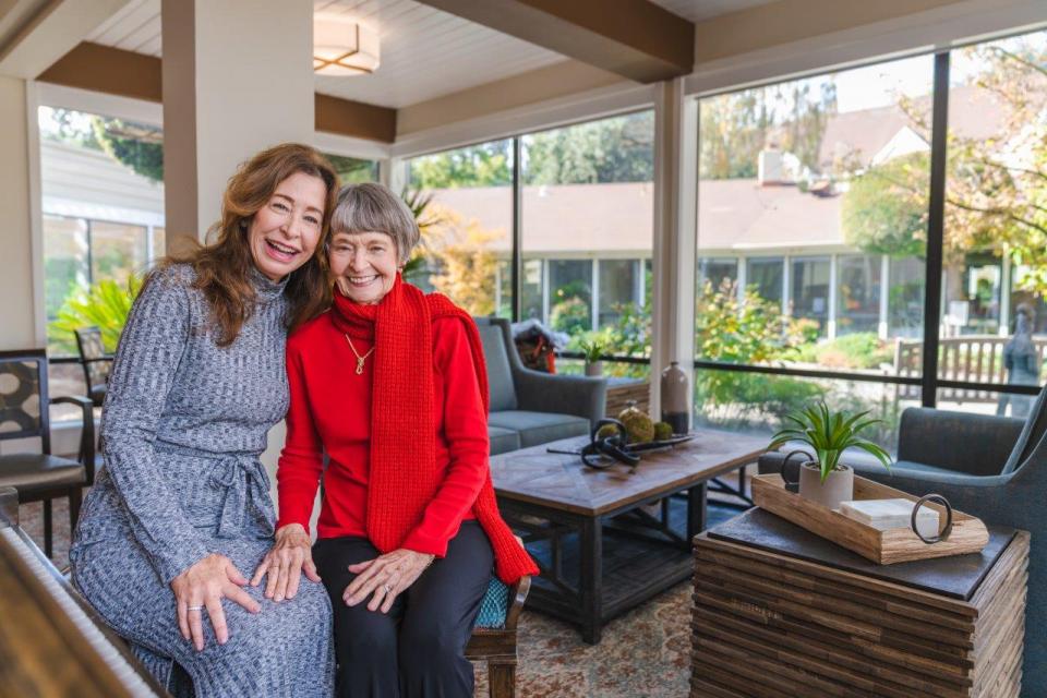 Mother and daughter sitting together smiling