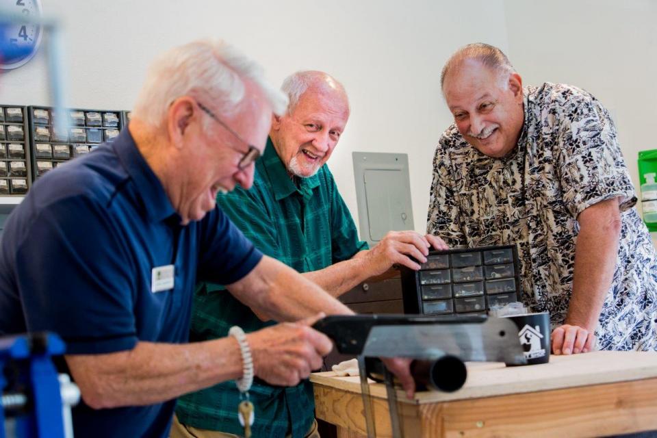 Three men working in the workshop and laughing