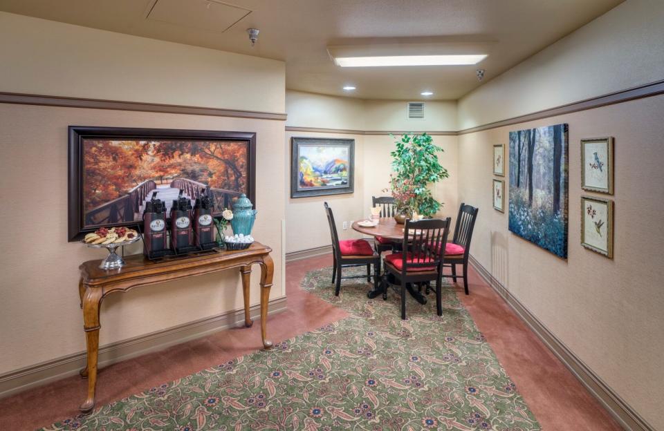 Cozy sitting area with table and four chairs, and a table with refreshments to eat and drink