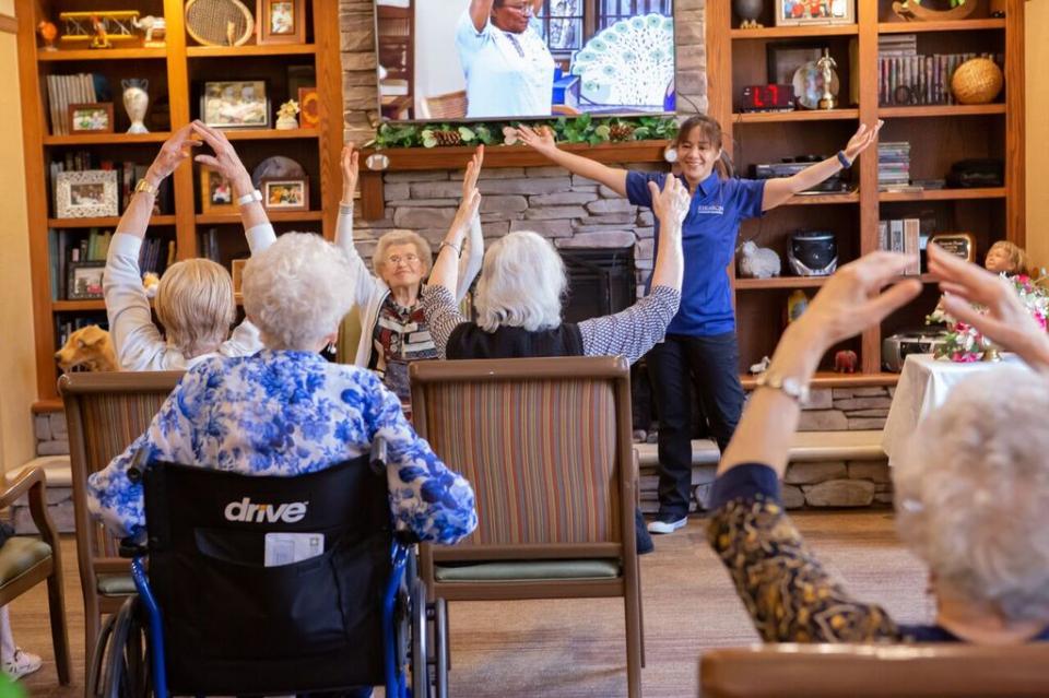 Staff member leading an exercise class with group of residents