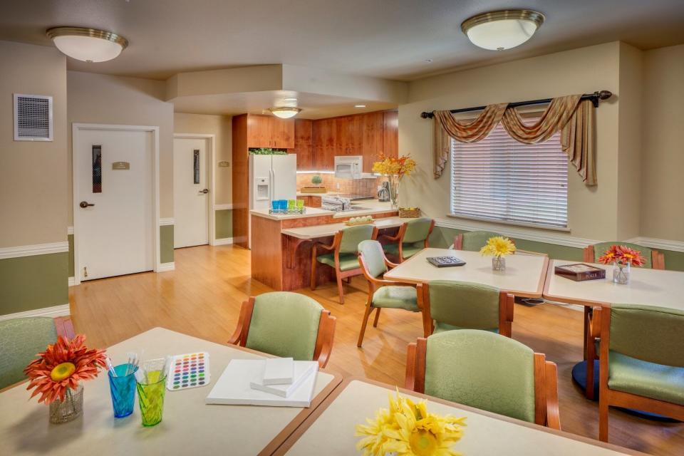 Activity room with tables and chairs and a  small kitchen area.