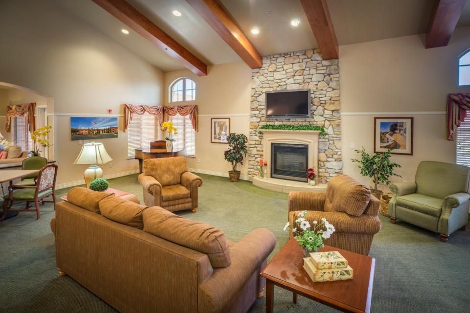 Community living room with a couch, three comfy chairs and a fireplace.