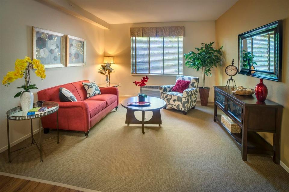 Apartment living room with an orange couch, coffee table and chair.