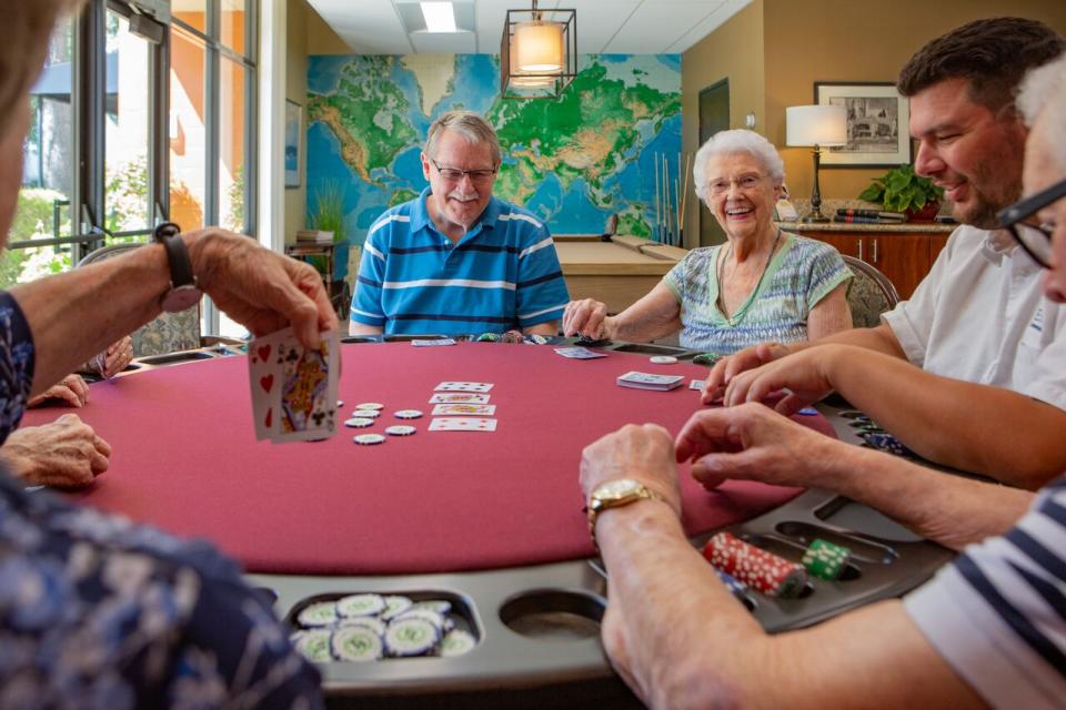 happy and smiling residents play a game of poker