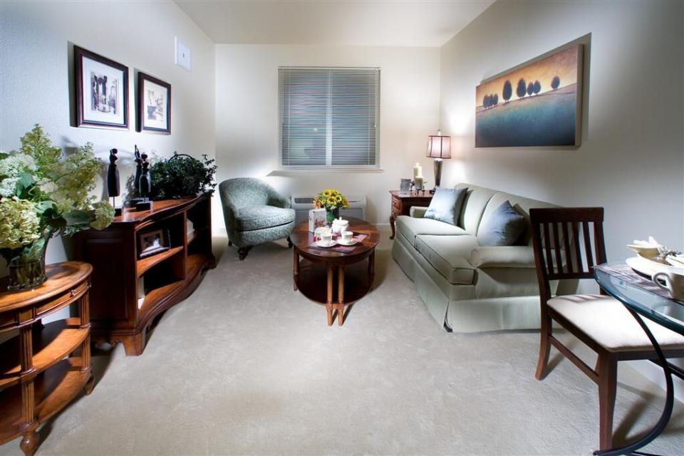 Apartment living room with a couch, chair, coffee table and end tables.