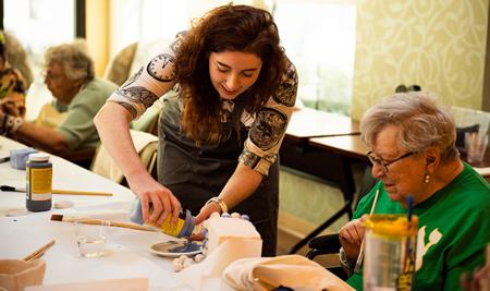 Staff providing paint to a resident for an art project