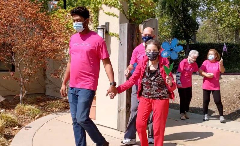 Staff and residents walking outside, around the community