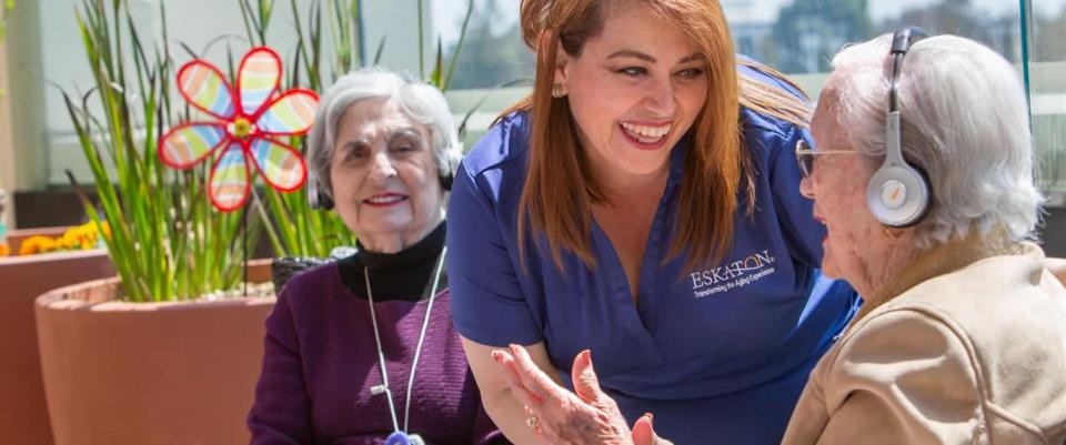 Staff and two residents wearing headsets listening to music.